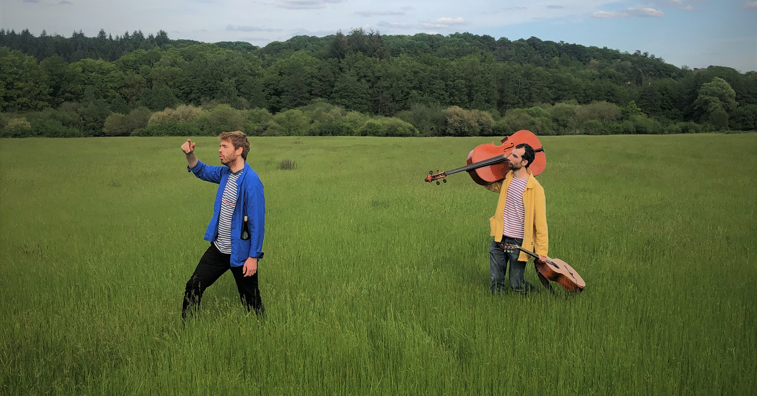 deux hommes dans un champs avec des instruments dans les mains