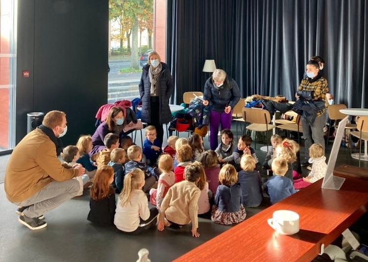Une classe assise dans le hall en attendant l'ouverture des portes de la salle de spectacle