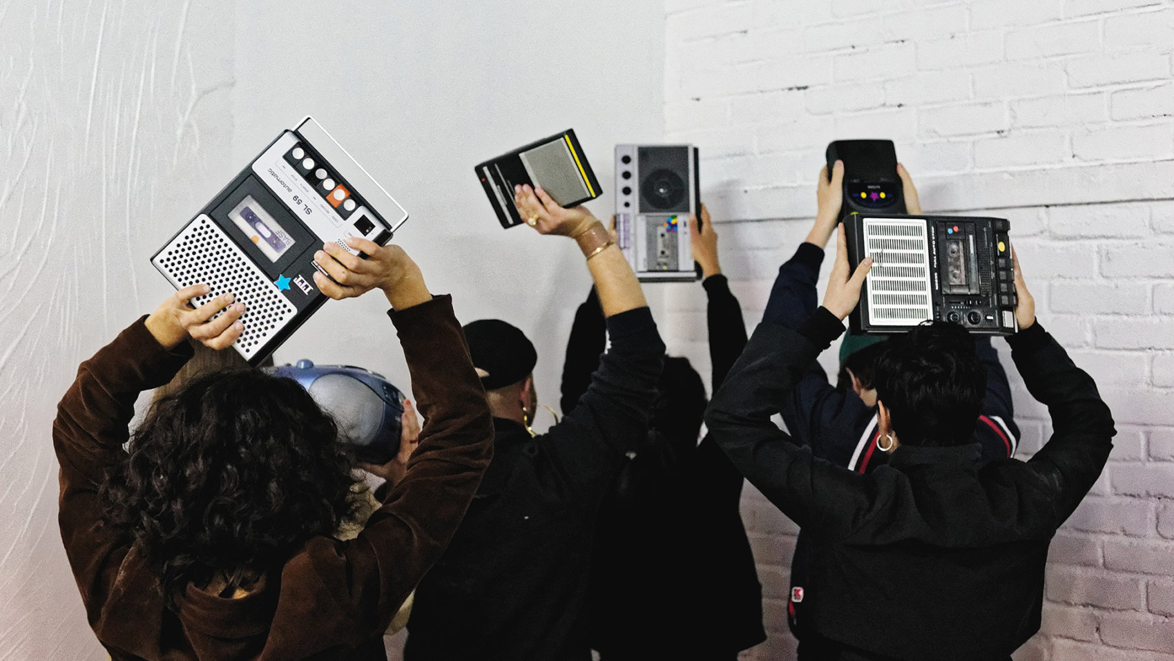 Groupe de personnes de dos levant des vieux lecteurs cassette