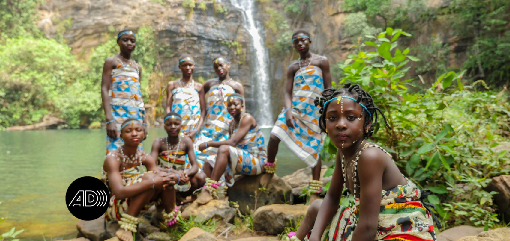 groupe en tenu traditionnelle devant une cascade