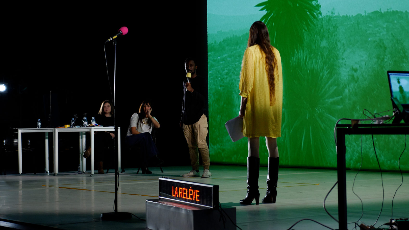 La scène de Radio Live avec une femme de dos en robe jaune