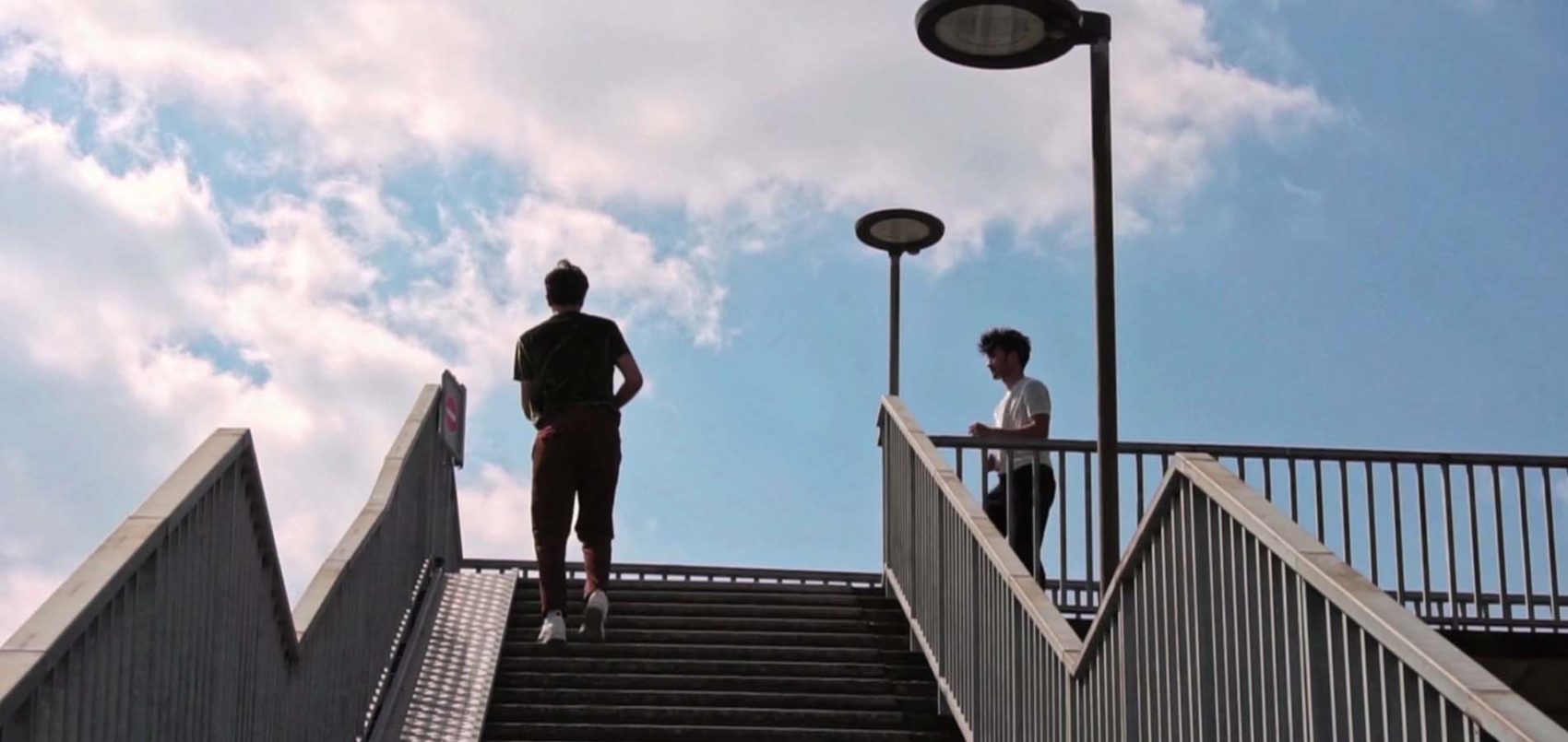 Photo d'un escalier en extérieur avec au fond la silhouette de deux hommes