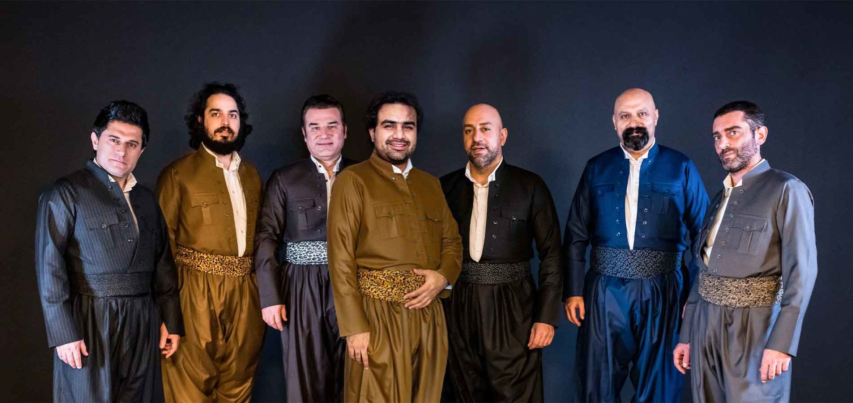Les sept musiciens et chanteurs de Nishtiman Project, prenne la pose, debout 