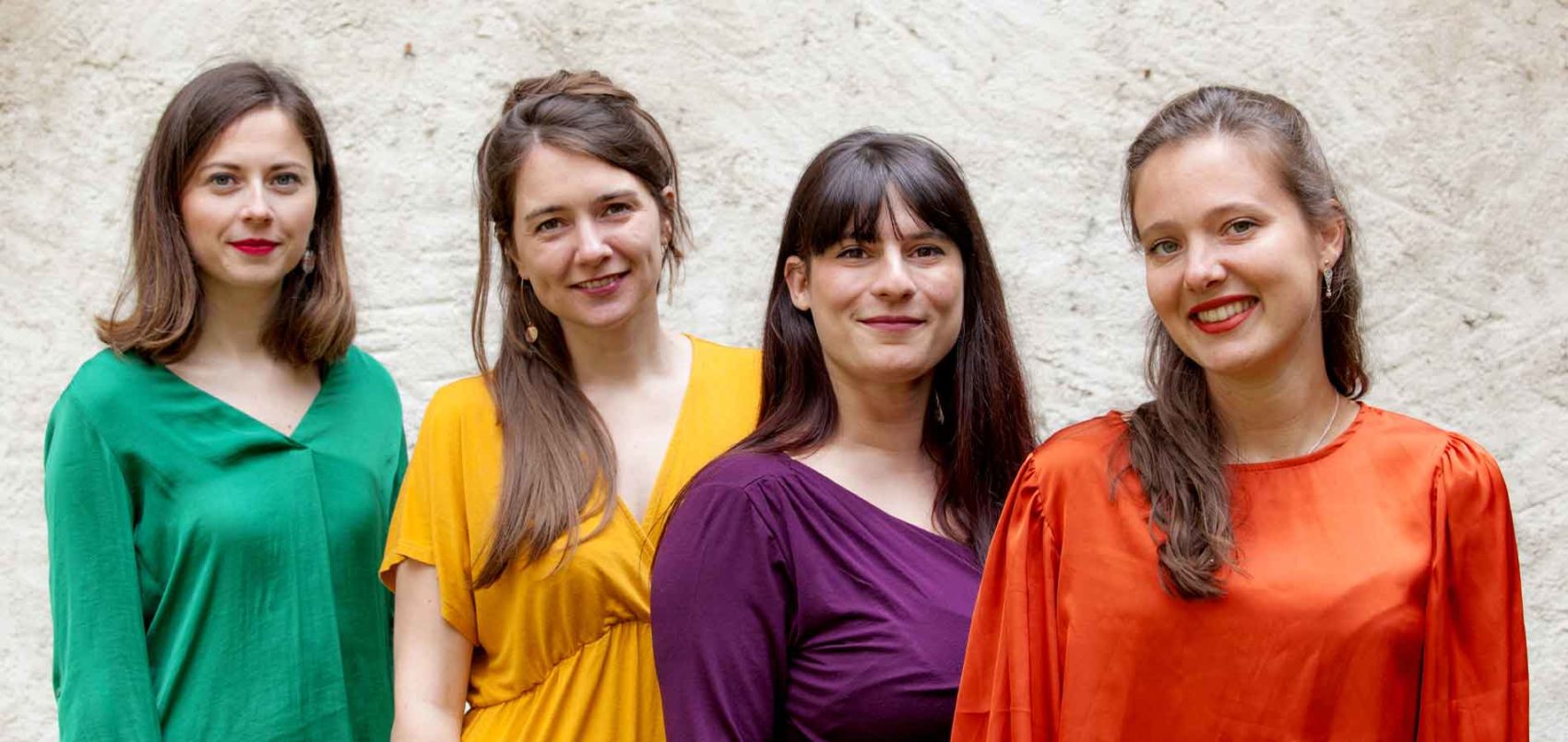 Portrait des quatre femmes de Kapsber'girls avec des haut de couleur vert, jaune, violet et orange
