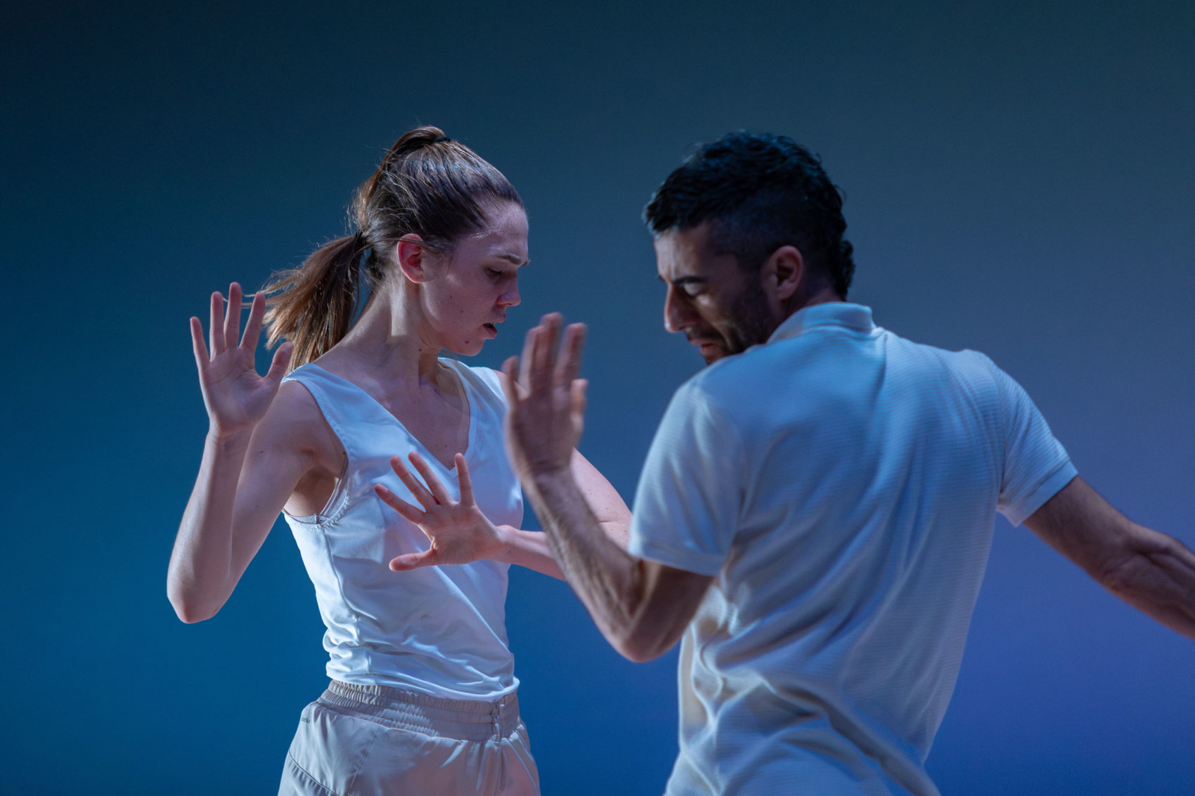 Les deux danseurs, un homme et une femme, se tiennent l'un derrière l'autre. Ils portent des bonnets rouges. 