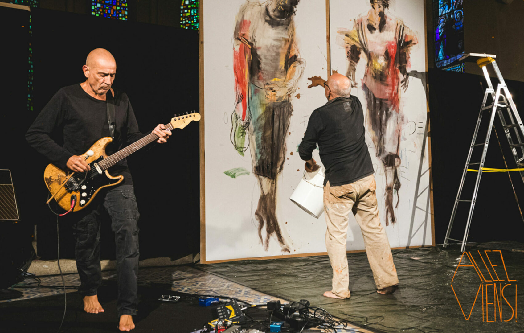 Photo de Ligne de front avec un guitariste à gauche et un peintre devant d'un géant en peinture à droite