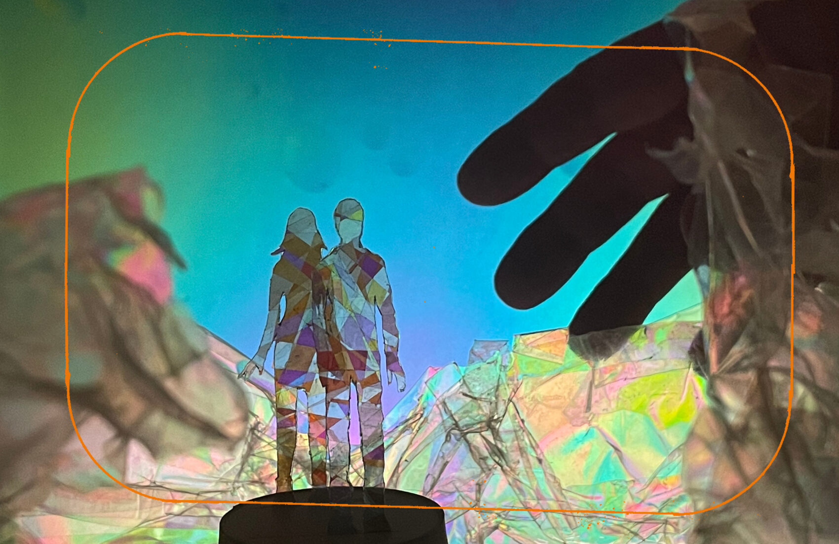 Image avec des personnages en papier et une main au dessus