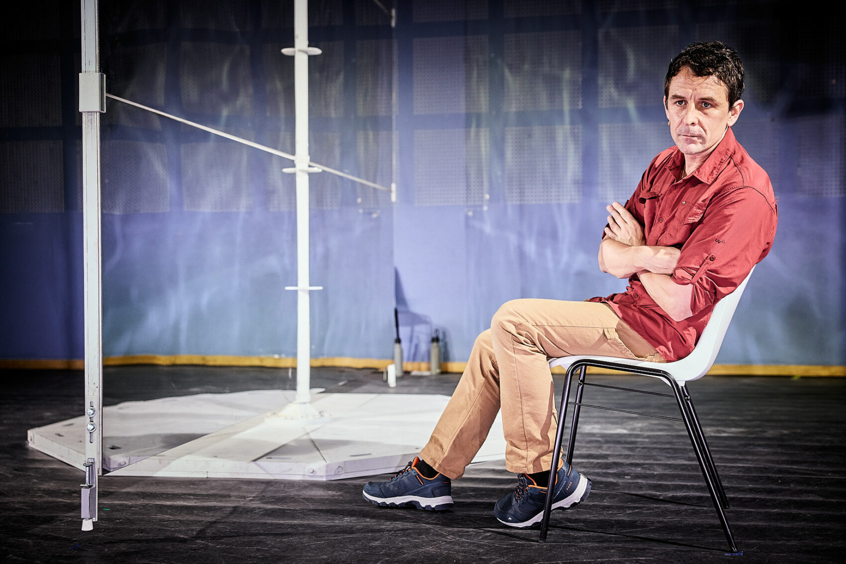 Une homme sur une chaise nous regardant 