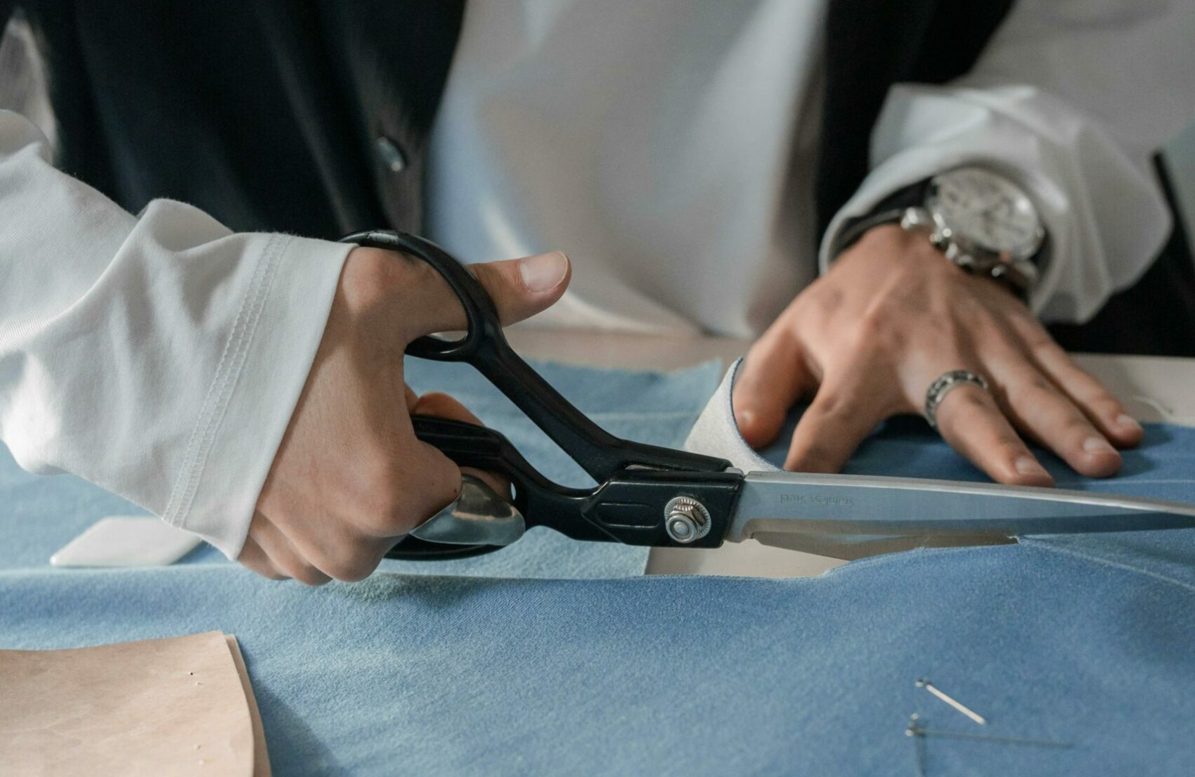 Mains en train de couper du tissu