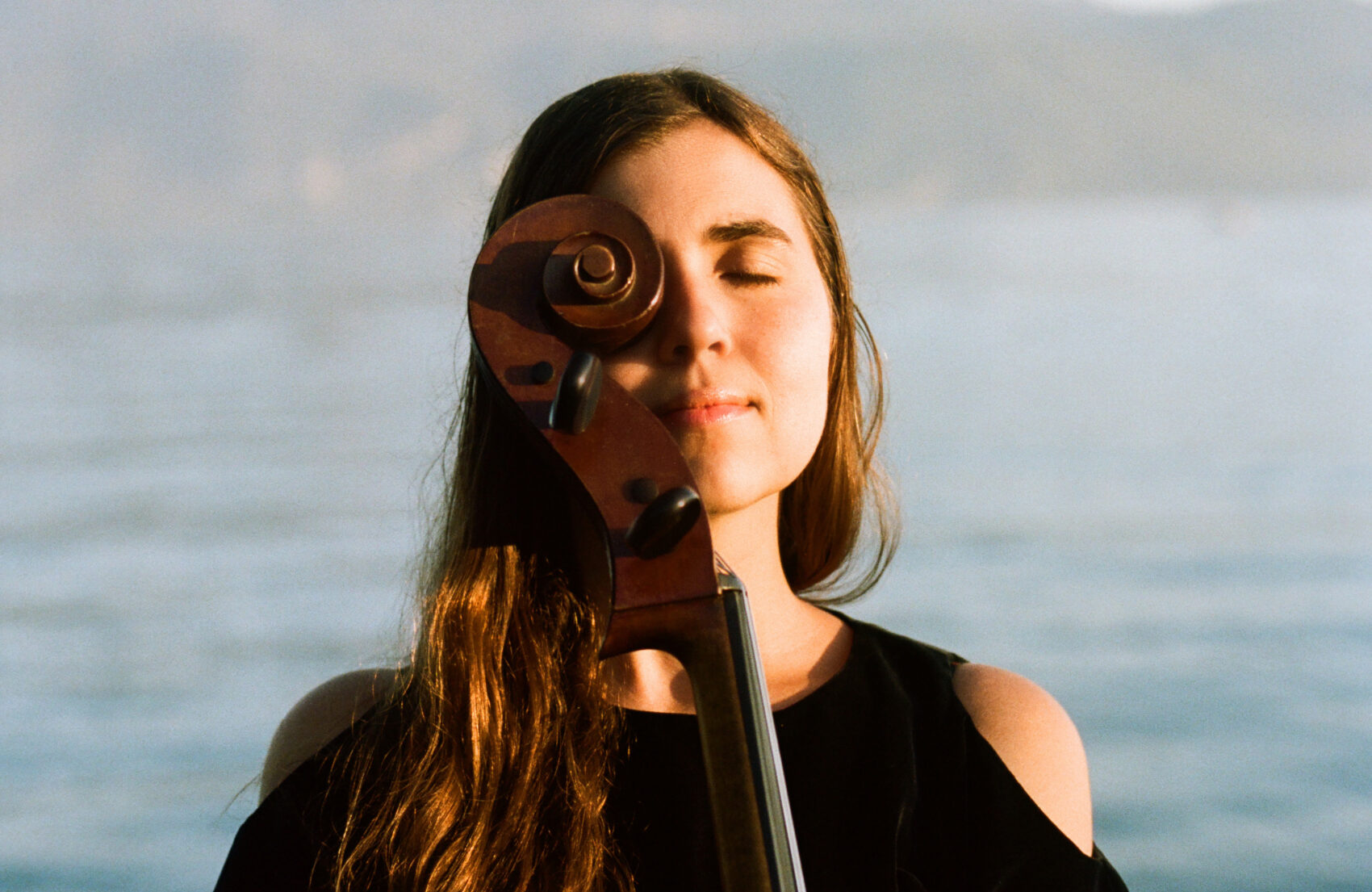 Portrait de la musicienne, avec le manche de son violoncelle sur la moitié de son visage