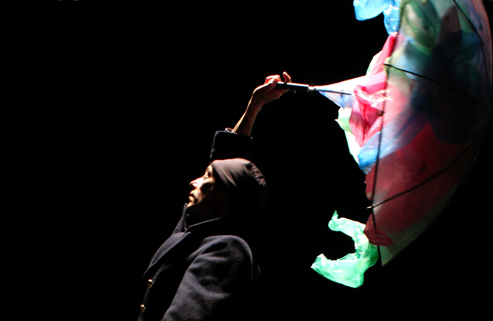 Photo de l'artiste tenant un parapluie rempli de sacs en plastique