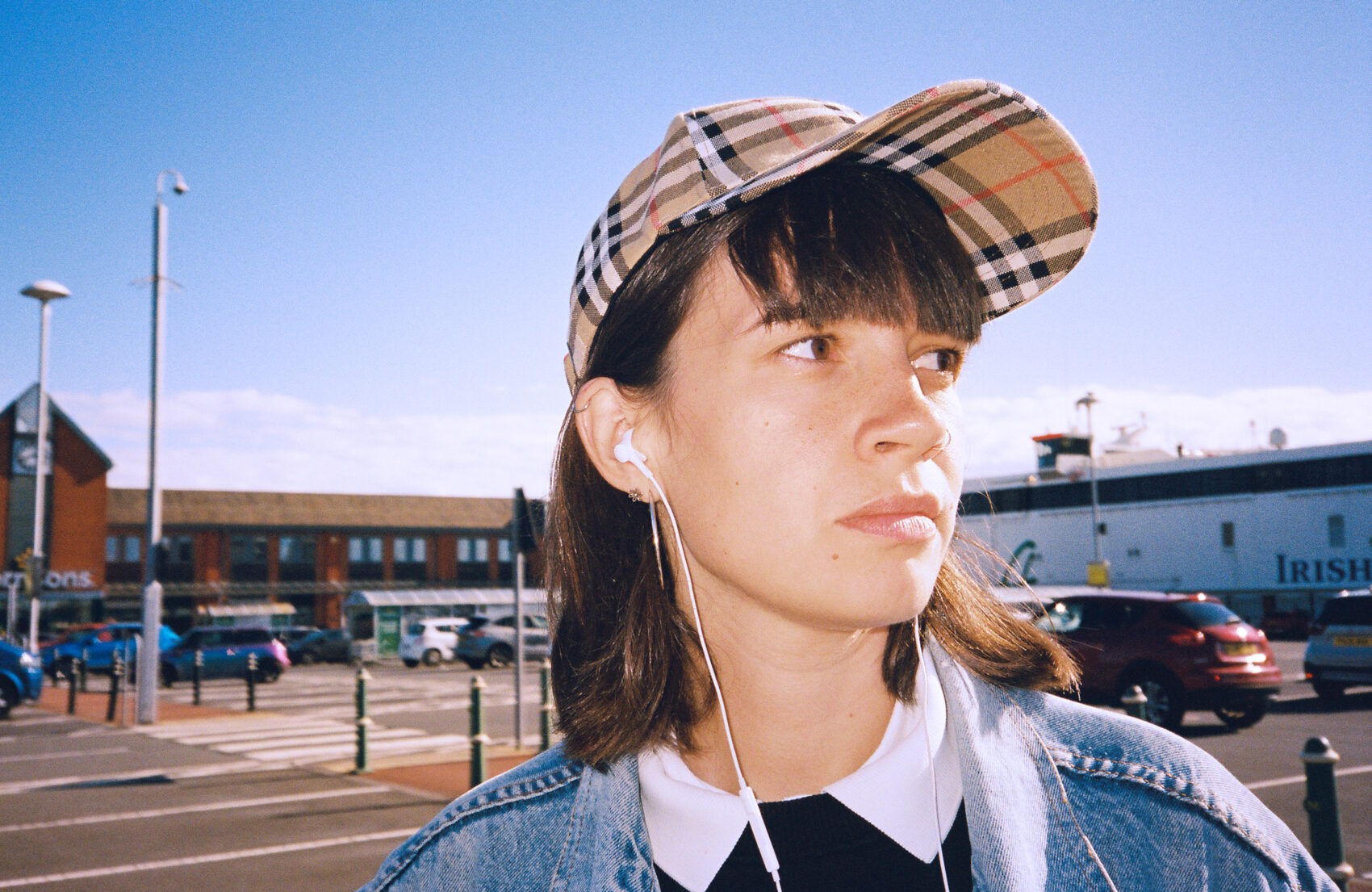 Photo de la chanteuse de profil, elle porte des écouteurs et une casquette