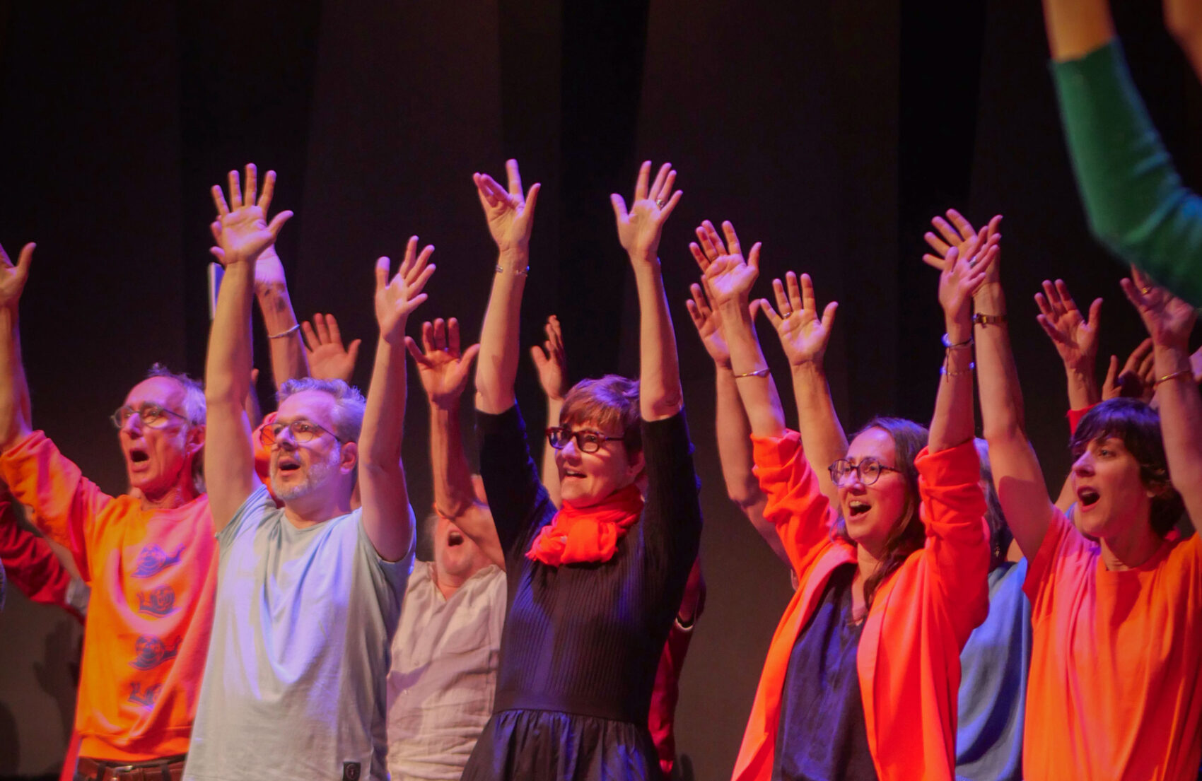 Photo d'un groupe de choristes chantant les bras levés