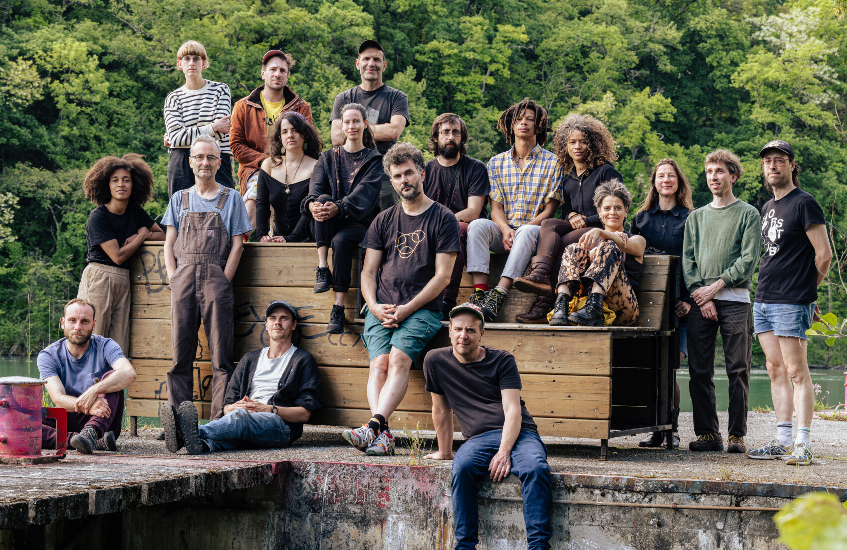 Photo des 18 musiciens et musiciennes autour d'une structure en bois.